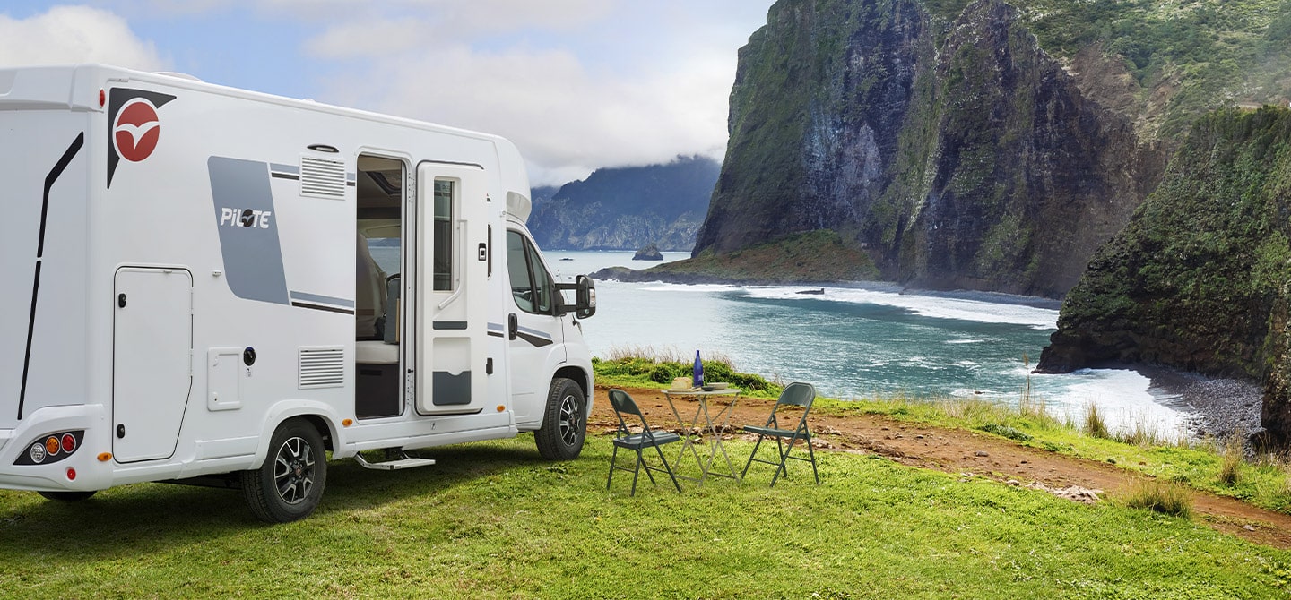 Camping-car intégral Pilote à l'arrêt pour la nuit, au bord d'une falaise donnant sur la mer.