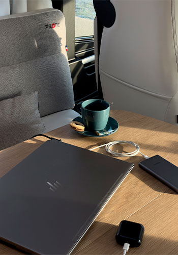 Ordinateur en train de charger sur la table d'un camping-car Pilote